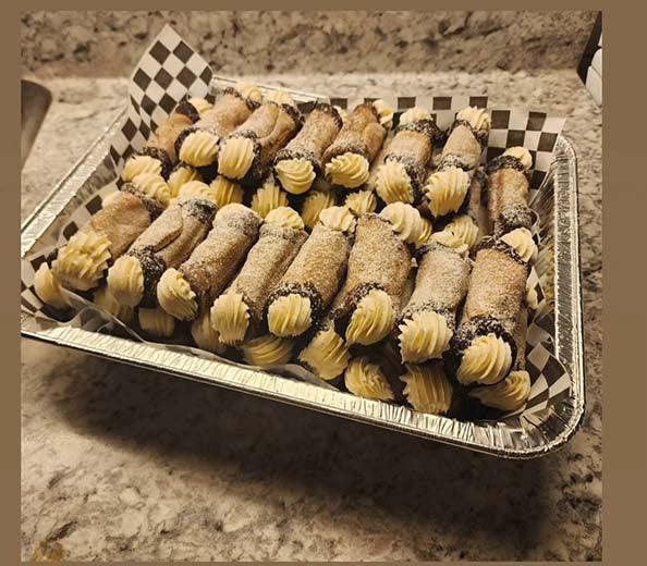 Gluten-free dog treats with creamy filling, dusted with cocoa, in a foil tray on countertop