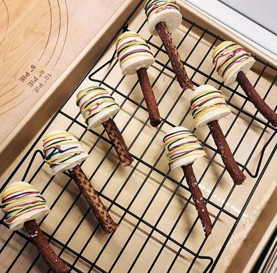 Gluten-free dog treats with colorful drizzle on cooling rack, handcrafted with human-grade ingredients