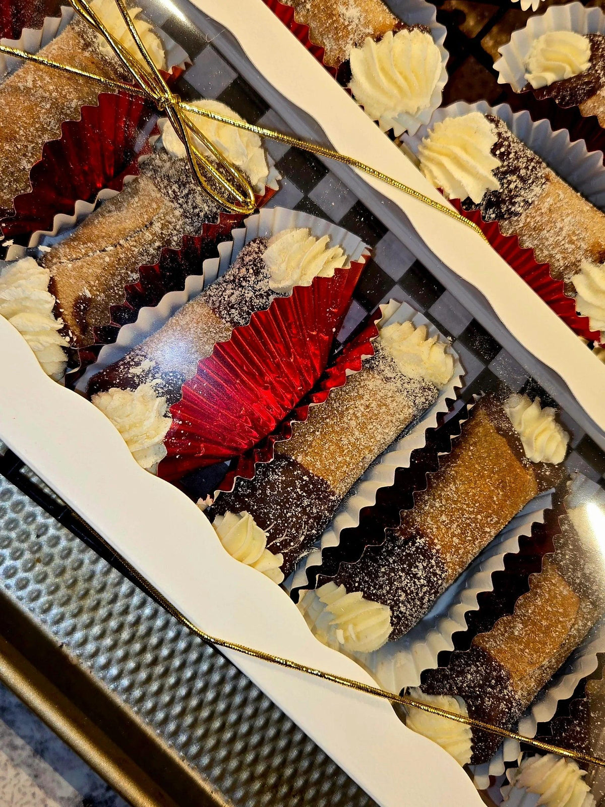 Two boxes of Barkday Treats Paw'Nolis dog cannolis with cream cheese filling, red cupcake liners and gold ribbon gift packaging
